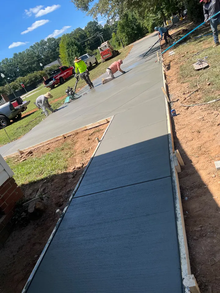 Fresh concrete walkway in the foreground with an EBC crew working on the connected placement.