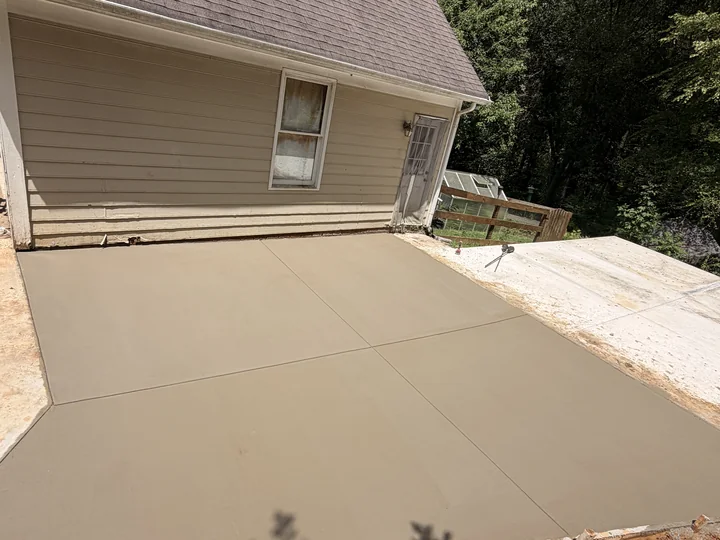 Fresh concrete entry beside a home, finished with clean control joints