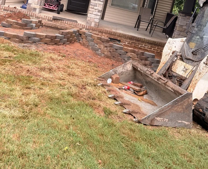 Curved block wall under construction beside a porch
